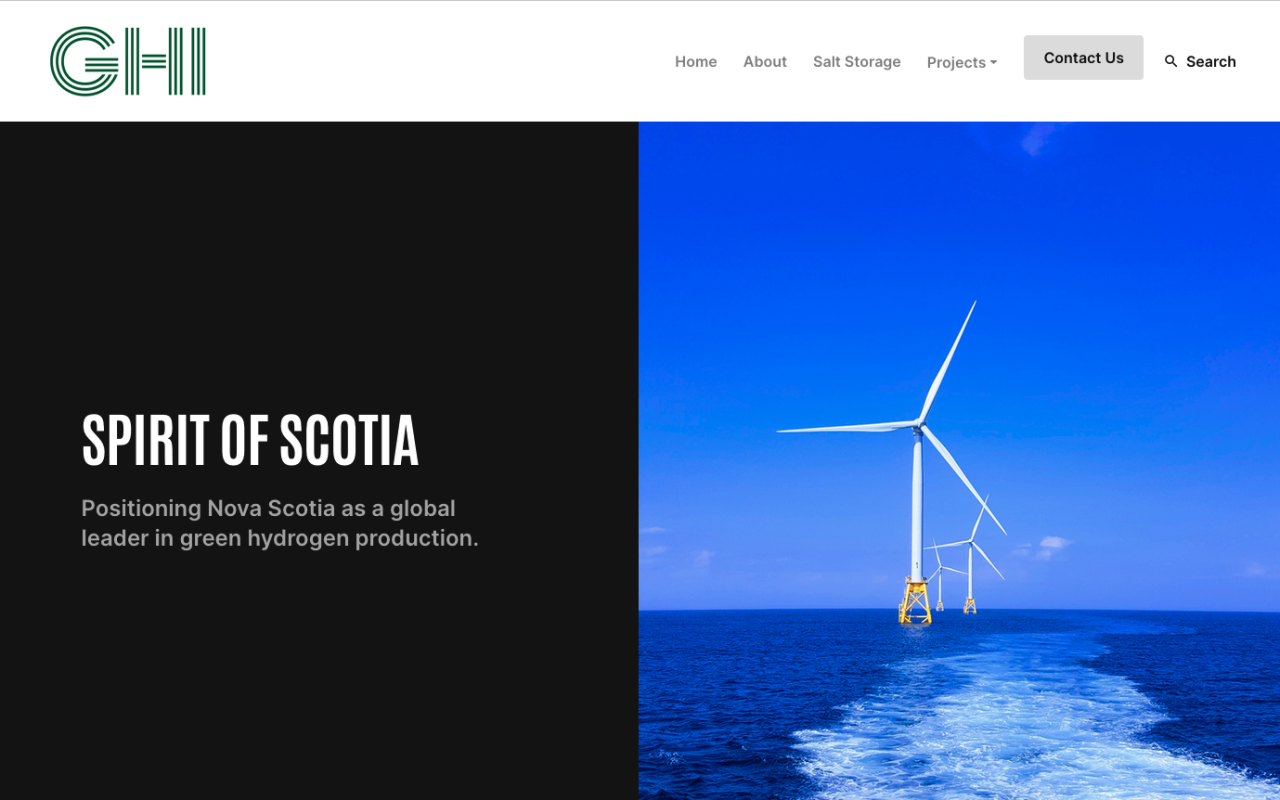 A screenshot from the GHI website, divided vertically into two squares. On the left, on a black background, in white print, the words "SPIRIT OF SCOTIA" and "Positioning Nova Scotia as a global leader in green hydrogen production." On the right side of the image, a photo with blue sky, blue ocean and three large wind turbines in the ocean, and a white frothy wake from a boat leading to them.